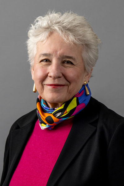 portrait of woman in black blazer, pink shirt and a multi color silk scarf